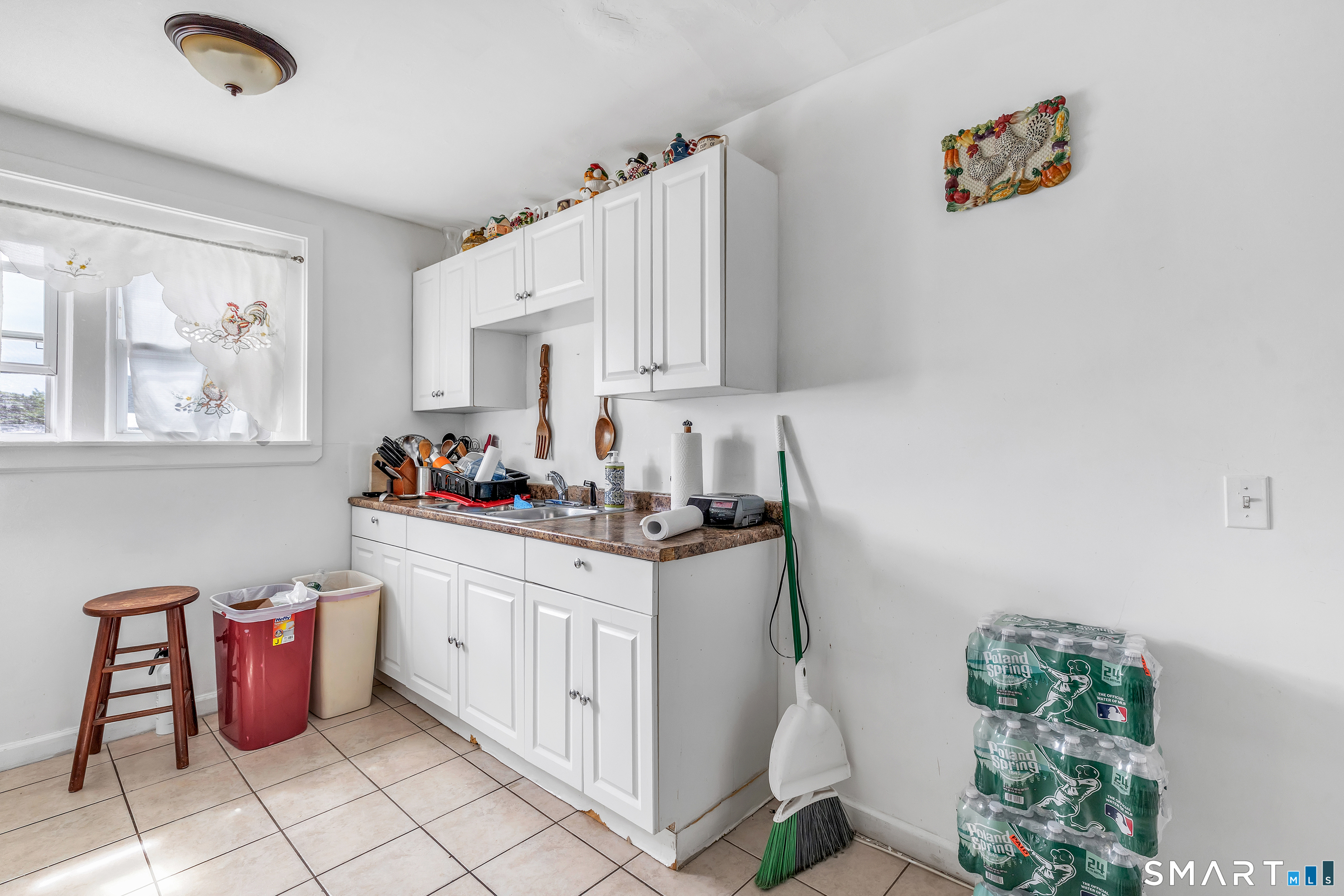 189 Wells Street Bridgeport, CT 06606 - Photo 25 of 40 3rd Floor - Offers 946 sq ft -Kitchen with white cabinets and electric stove and fridge, washer/dryer