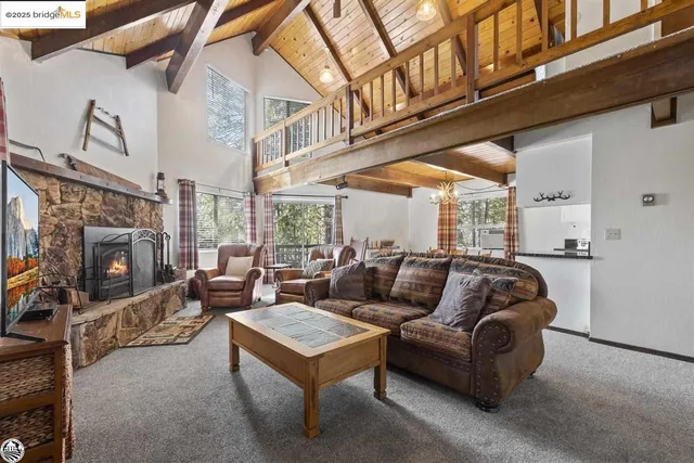 a living room with furniture a fireplace and a large window
