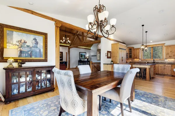 a view of a dining room with furniture a chandelier and wooden floor
