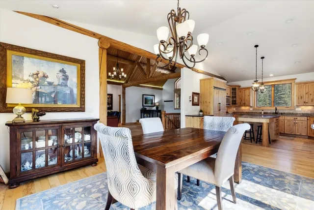 a view of a dining room with furniture a chandelier and wooden floor