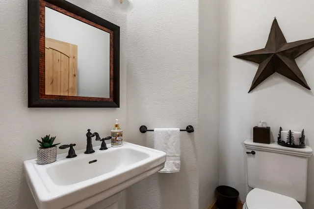 a bathroom with a toilet a sink and mirror