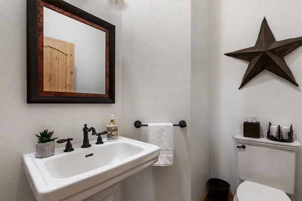 a bathroom with a toilet a sink and mirror