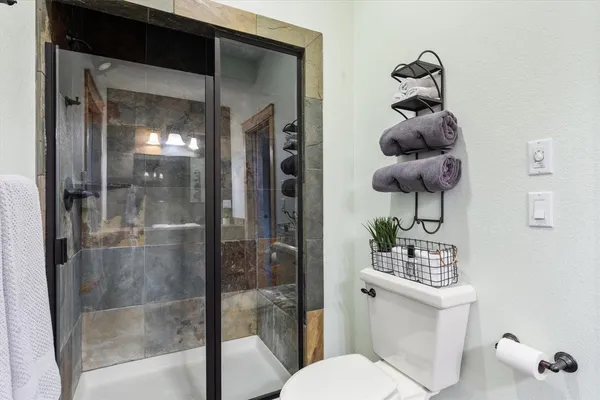 a bathroom with a toilet a sink and shower