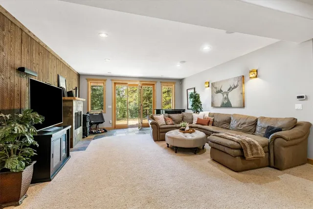 a living room with furniture flat screen tv and large windows