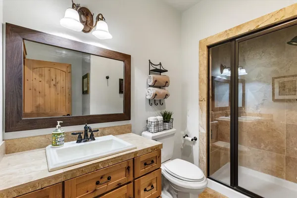a bathroom with a sink a toilet and shower