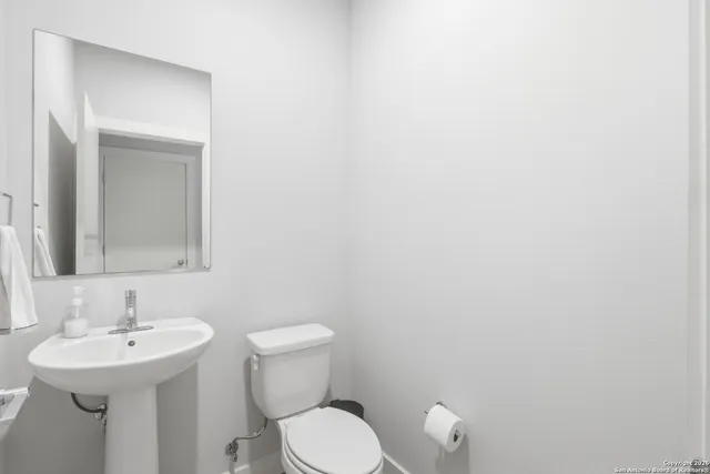 a bathroom with a sink a toilet and a mirror