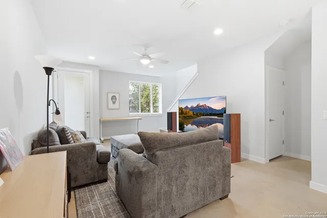 a living room with furniture and a book shelf