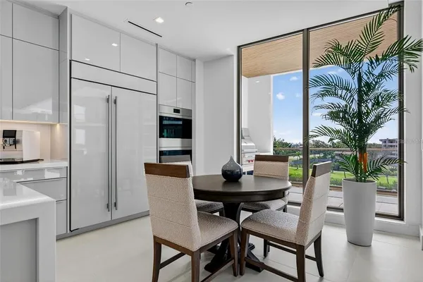 a kitchen with a dining table chairs and cabinets