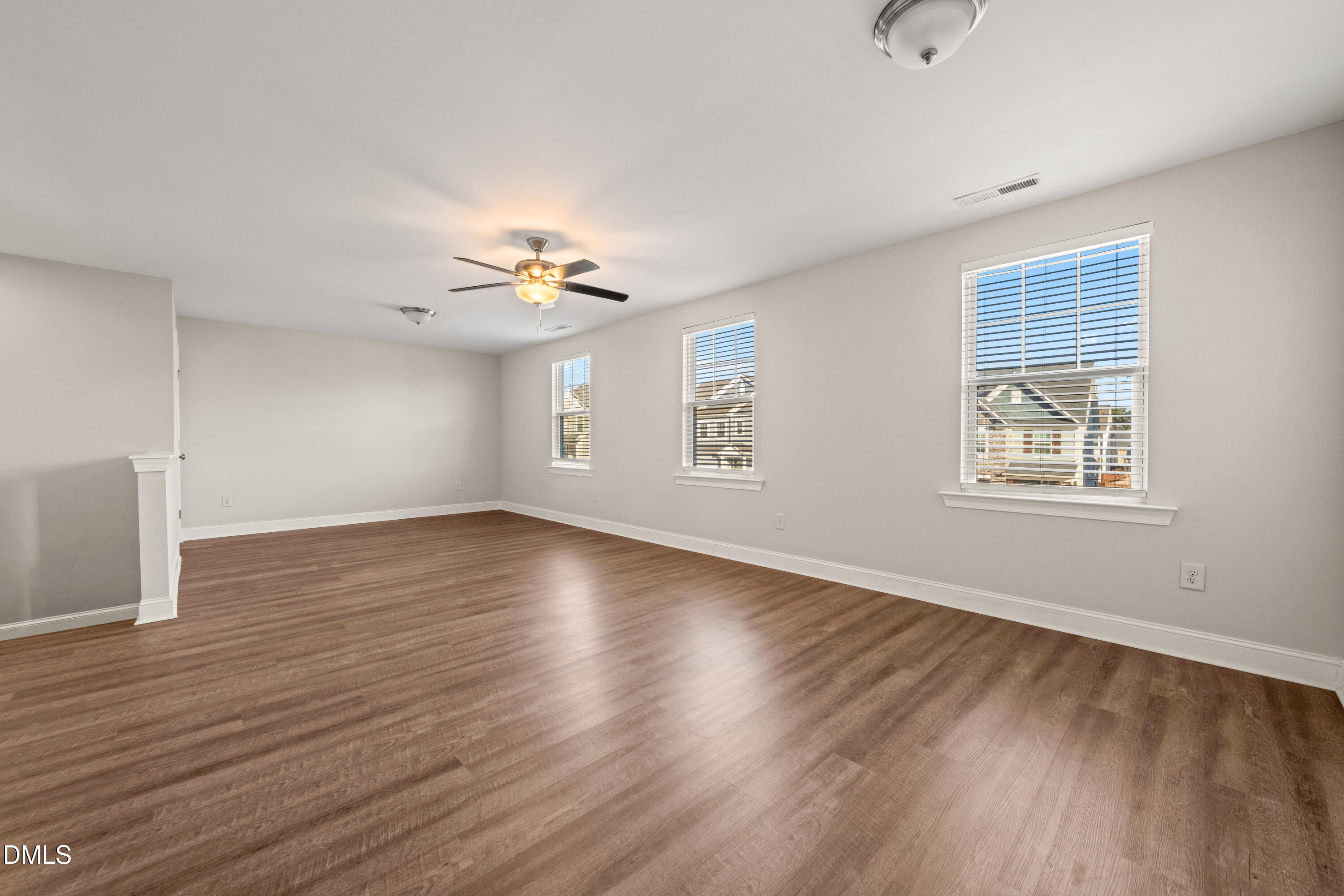 4508 Brintons Cottage Street Raleigh, NC 27616 - Photo 21 of 46 an empty room with wooden floor chandelier and windows