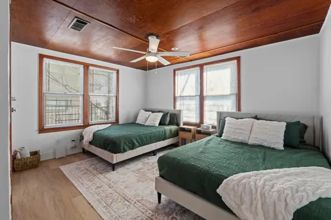 a bedroom with two beds and a large window