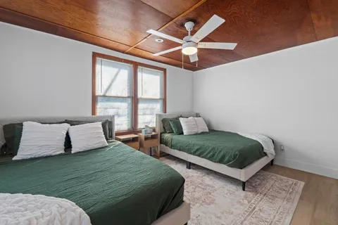 a bedroom with 2 bed and a large window