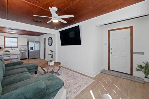 a living room with furniture a ceiling fan and a rug
