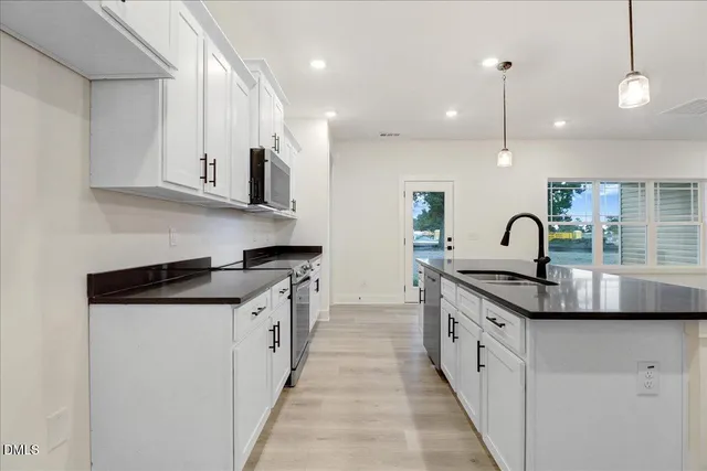 a kitchen with granite countertop a stove and a sink