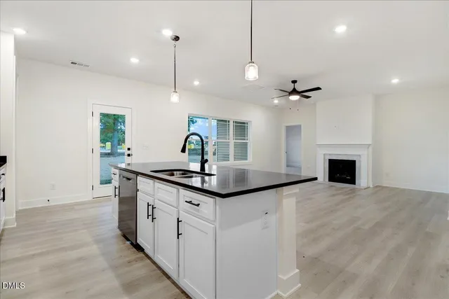 a kitchen with granite countertop a sink a stove and cabinets