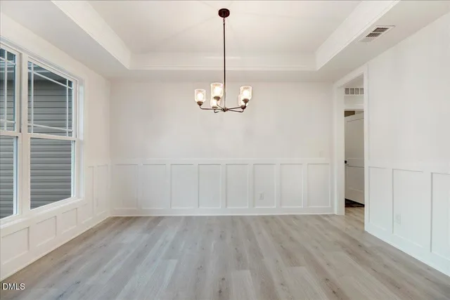 an empty room with windows fireplace and a sink