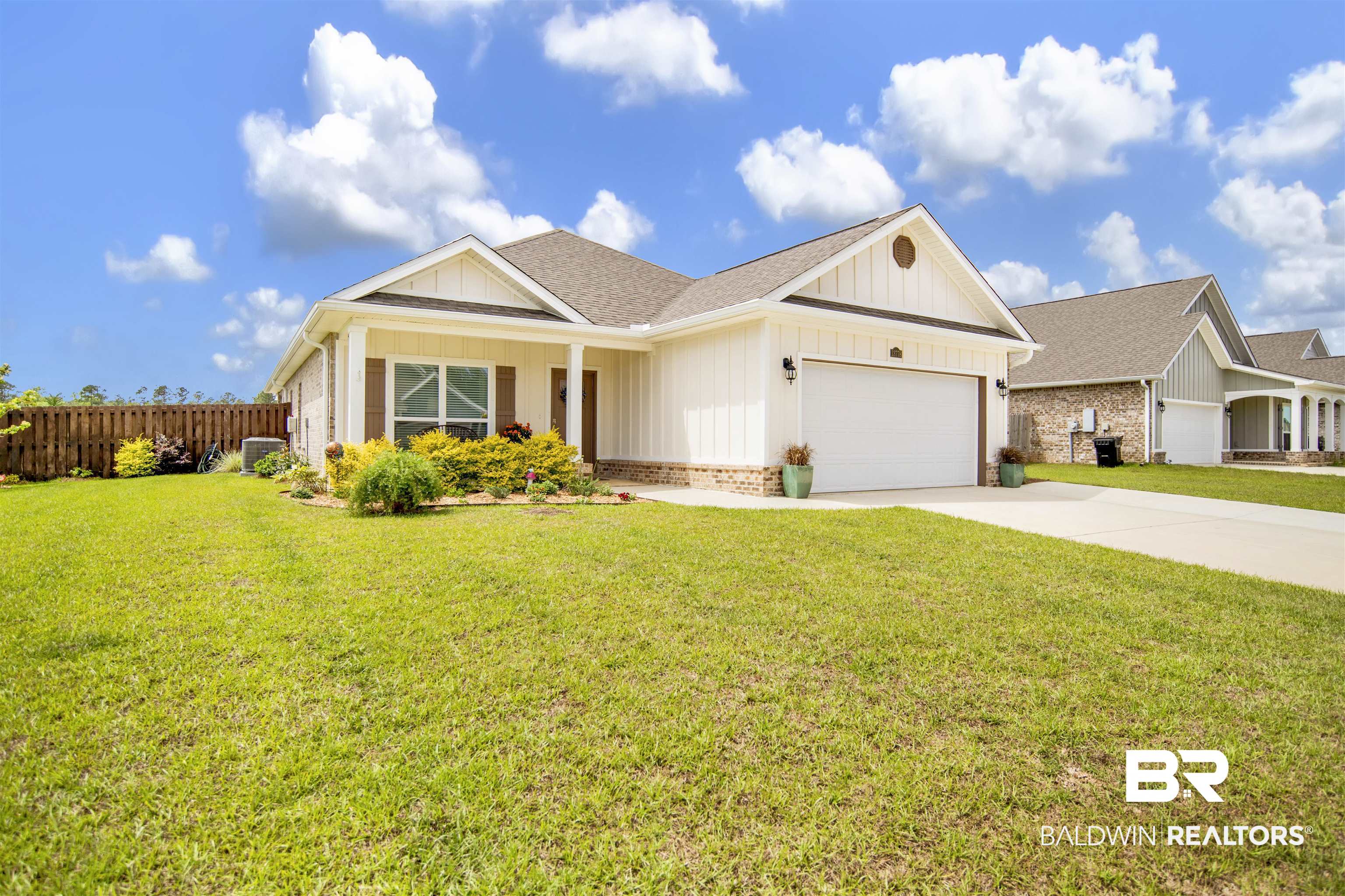 View of front of home with a porch, board and batten siding, a garage, roof with shingles, and concrete driveway