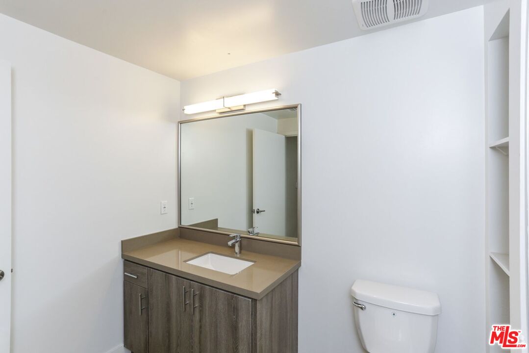 744 Hartford Avenue, Unit 206 Los Angeles, CA 90017 - Photo 18 of 23 a bathroom with a toilet sink and mirror