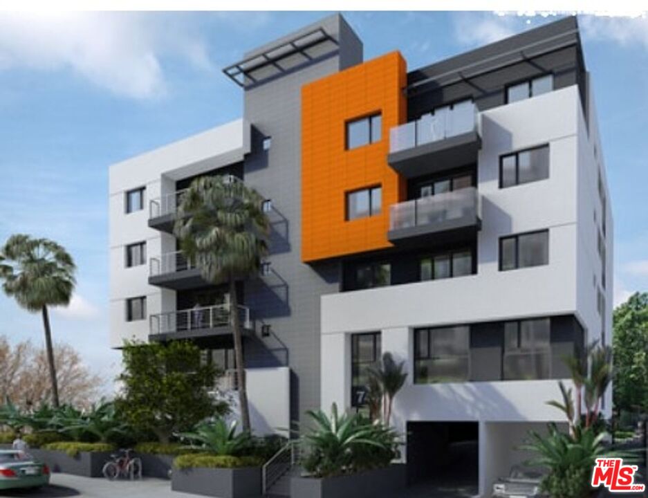 744 Hartford Avenue, Unit 206 Los Angeles, CA 90017 - Photo 2 of 23 a yellow building with potted plants in front of it