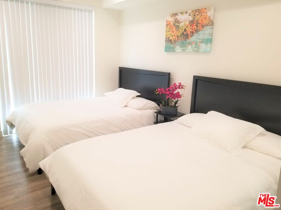 744 Hartford Avenue, Unit 206 Los Angeles, CA 90017 - Photo 10 of 23 a bedroom with two bed and a painting on the wall