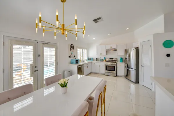 a kitchen with white cabinets and stainless steel appliances