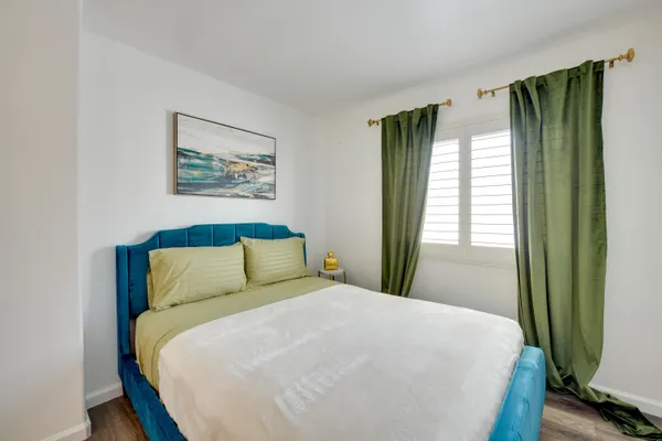 a bed sitting in a bedroom next to a window