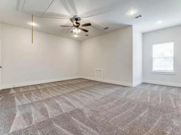 an empty room with fan and windows