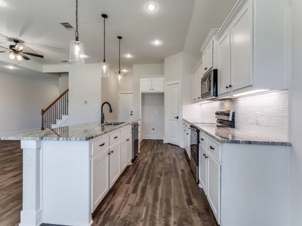 a kitchen with a sink stove and cabinets