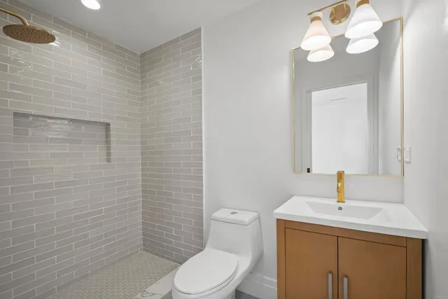 a bathroom with a toilet sink vanity and mirror