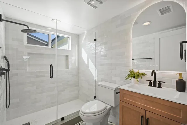 a bathroom with a sink a toilet and shower