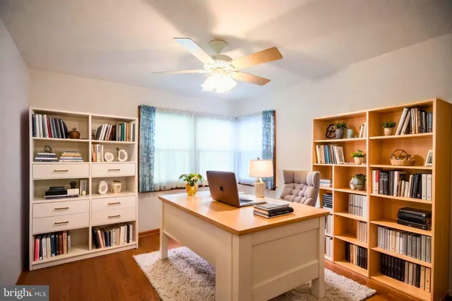 a view of a workspace with furniture and a bookshelf