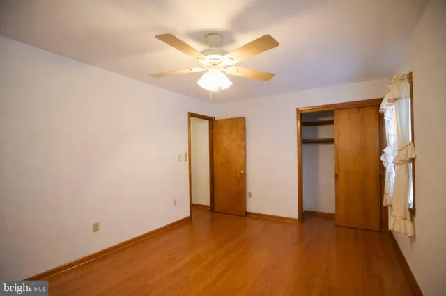 a view of an empty room with closet and a chandelier fan