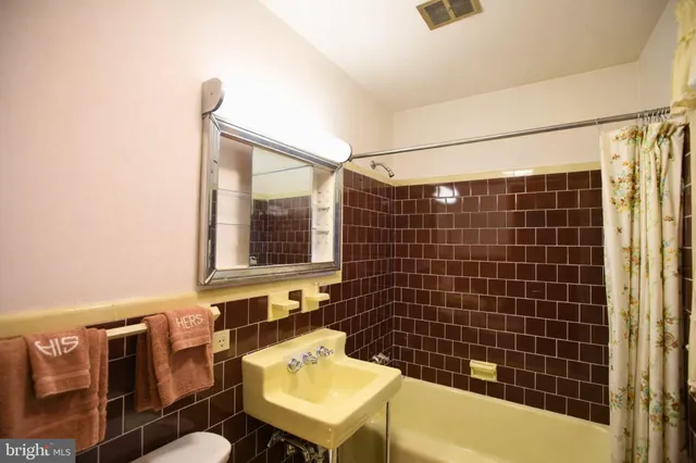 a bathroom with a sink mirror and a bathtub