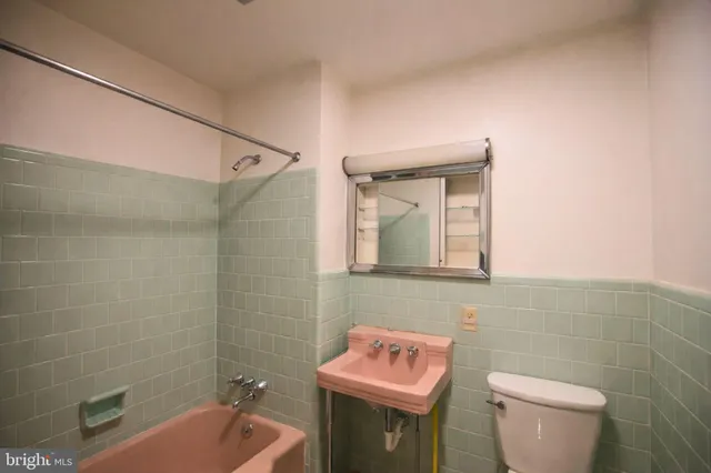 a bathroom with a sink toilet and mirror
