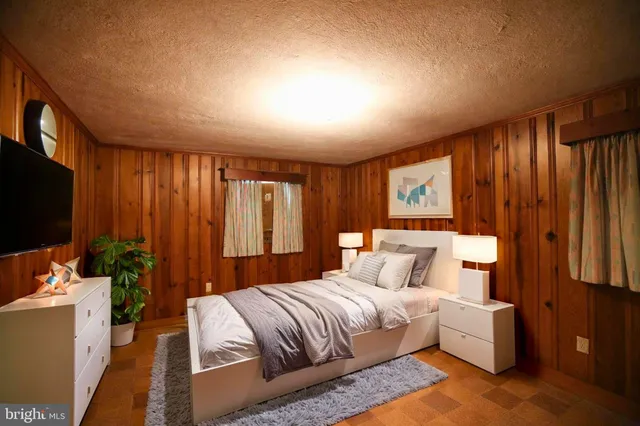 a bedroom with furniture and a flat screen tv