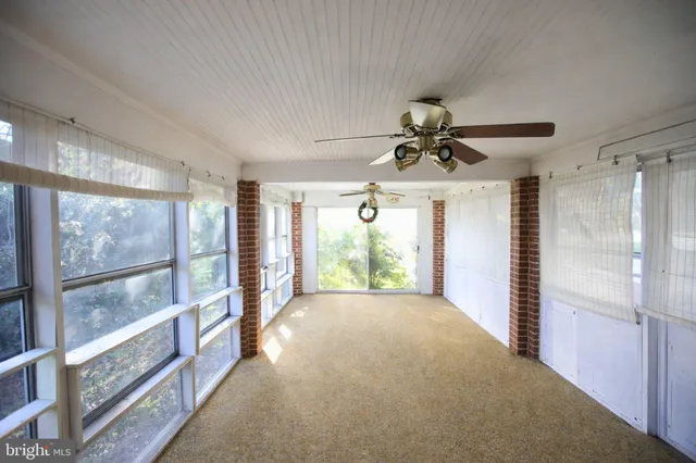 a view of a livingroom with a ceiling fan and window