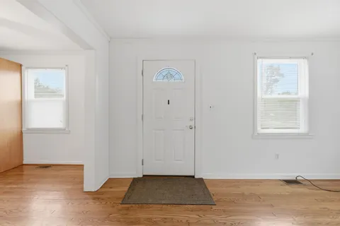 a view of an empty room with window and closet area