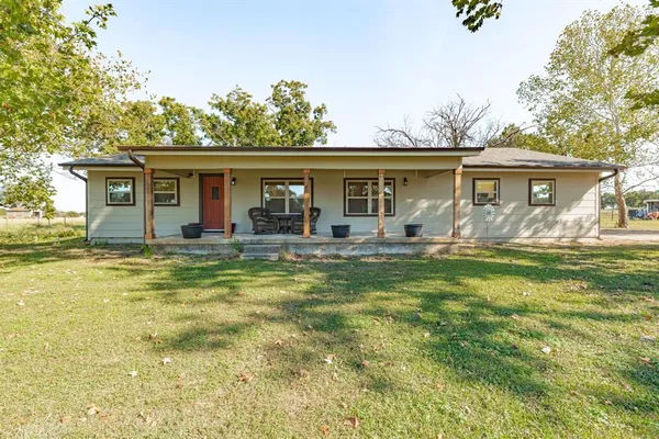 a front view of house with yard outdoor seating and green space