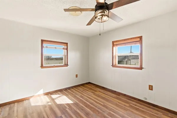 a view of empty room with wooden floor