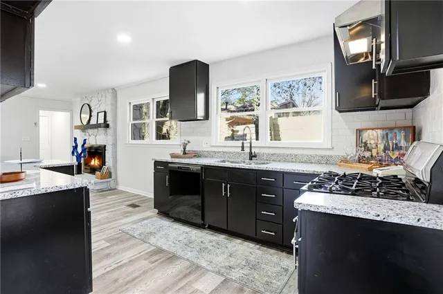 a kitchen with stainless steel appliances granite countertop a sink stove and cabinets