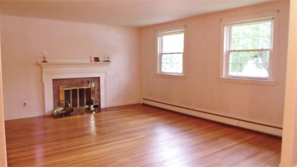 9 Patton Road Salem, MA 01970 - Photo 2 of 12 an empty room with wooden floor fireplace and windows