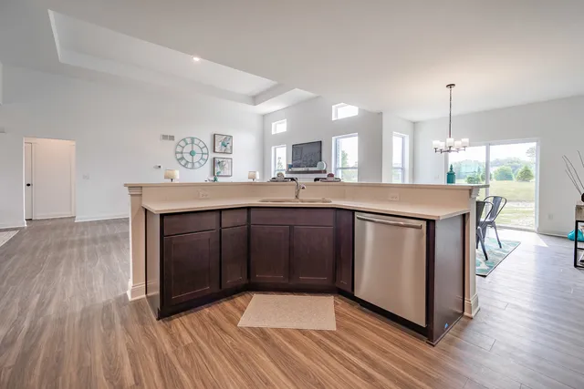 a kitchen with stainless steel appliances granite countertop a stove a sink and a wooden floors
