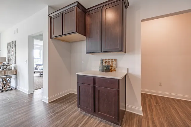 a kitchen with wooden floor and cabinets