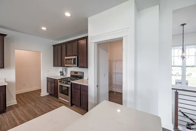 a kitchen with stainless steel appliances granite countertop a stove a sink and a refrigerator