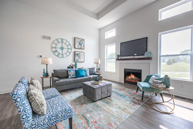 a living room with furniture a flat screen tv and a fireplace