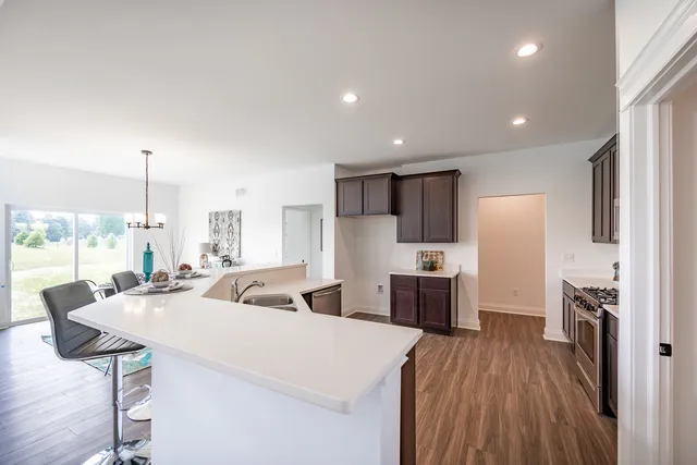 a large kitchen with stainless steel appliances a large counter top a stove a chimney a sink and a refrigerator