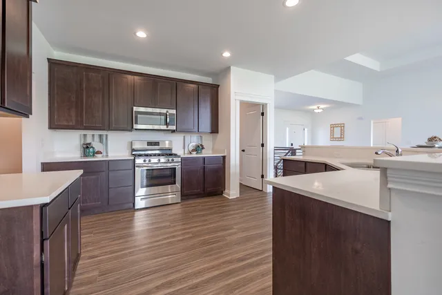 a kitchen with stainless steel appliances granite countertop a sink a stove top oven a counter space and cabinets