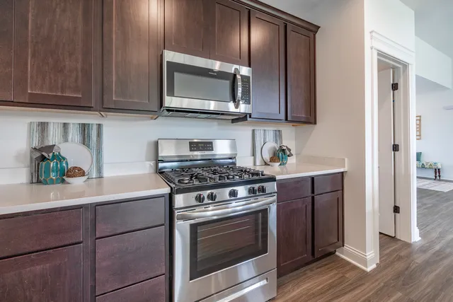 a kitchen with stainless steel appliances granite countertop a stove microwave and cabinets