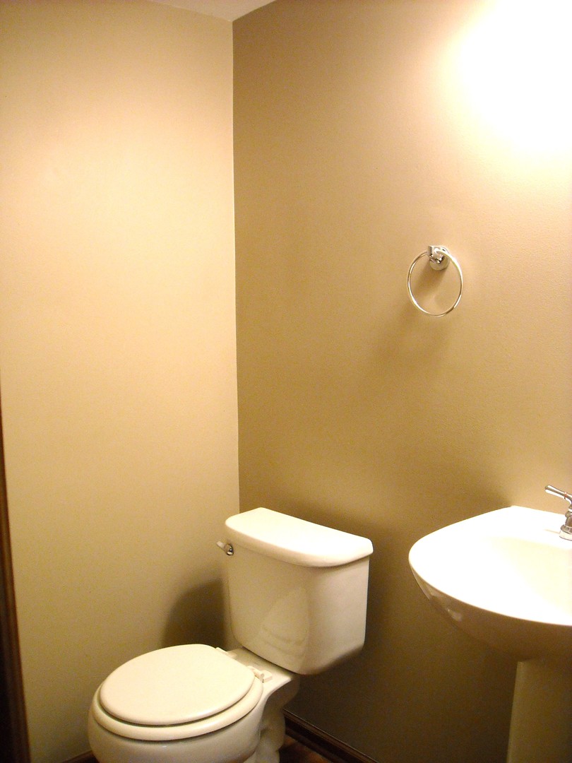 Undisclosed Address Aurora, IL 60504 - Photo 9 of 12 a white toilet sitting next to a bathroom sink