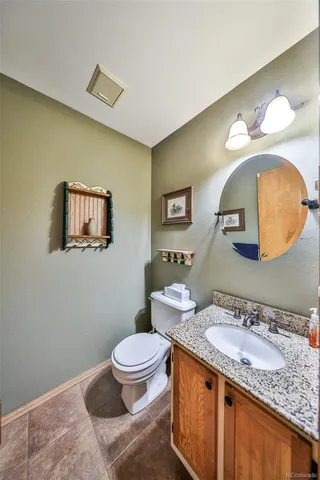 a bathroom with a granite countertop toilet sink and mirror