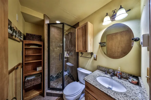 a bathroom with a granite countertop bathtub sink vanity mirror and toilet